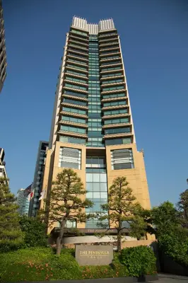 a tall building with trees in front of it at The Peninsula Tokyo in Tokyo