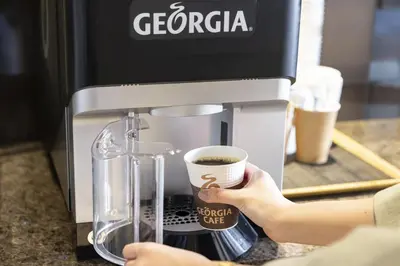 a person is making coffee in a coffee machine at Tokyu Stay Suidobashi in Tokyo