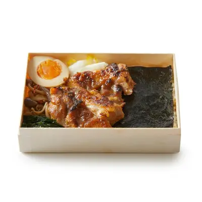 a box of food with meat and an egg at TSUKI Tokyo in Tokyo