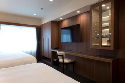 a hotel room with a bed and a tv at Kadoya Hotel in Tokyo