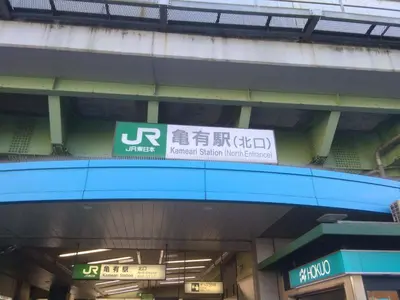 a sign for a subway station with signs on it at Nice Hostel Kameari in Tokyo