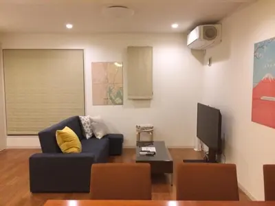 a living room with a blue couch and a tv at 3LDK, Functional and New house in convenient Shinjuku in Tokyo