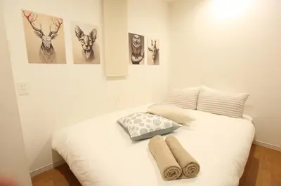 a bedroom with a white bed with two towels on it at 3LDK, Functional and New house in convenient Shinjuku in Tokyo