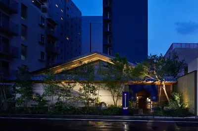 a building in the middle of a city at night at ONSEN RYOKAN YUEN SHINJUKU in Tokyo