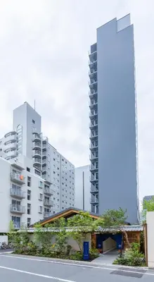 a building in front of some tall buildings at ONSEN RYOKAN YUEN SHINJUKU in Tokyo