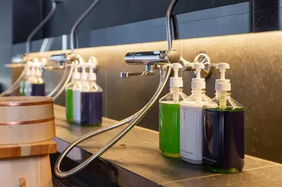 a group of four bottles sitting on top of a counter at ONSEN RYOKAN YUEN SHINJUKU in Tokyo