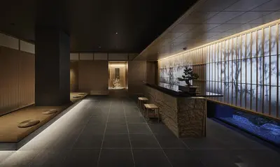 a lobby with a counter and a fish tank at ONSEN RYOKAN YUEN SHINJUKU in Tokyo