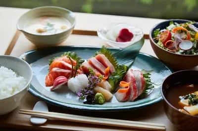 a plate of food with sushi and rice on a table at ONSEN RYOKAN YUEN SHINJUKU in Tokyo