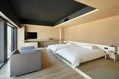 a bedroom with two beds and a flat screen tv at ONSEN RYOKAN YUEN SHINJUKU in Tokyo