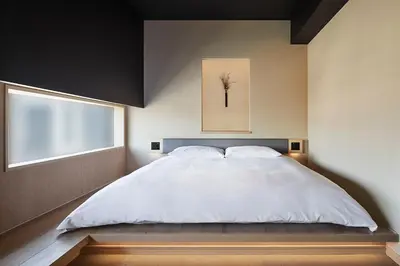 a bedroom with a large white bed and a window at ONSEN RYOKAN YUEN SHINJUKU in Tokyo