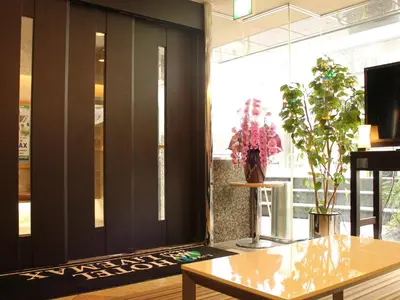 a living room with a table and a large window at HOTEL LiVEMAX BUDGET Shinbashi in Tokyo