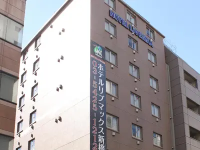 a building with a sign for the hotel at HOTEL LiVEMAX BUDGET Shinbashi in Tokyo