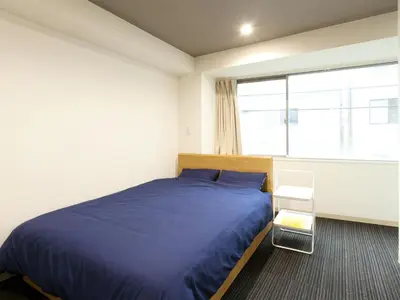 a bedroom with a blue bed and a window at Hotel Cocoro Inn Asakusa Kuramae in Tokyo