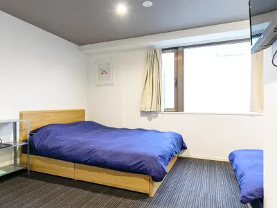 a bedroom with two beds and a window at Hotel Cocoro Inn Asakusa Kuramae in Tokyo