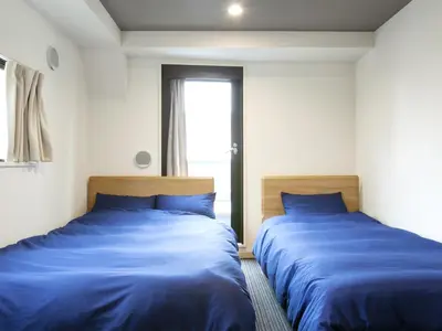 two beds sitting next to each other in a room at Hotel Cocoro Inn Asakusa Kuramae in Tokyo
