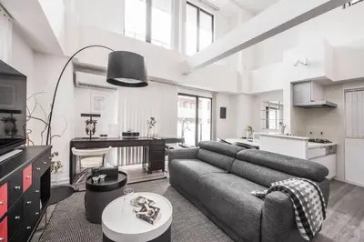 a living room with a couch and a kitchen at LANG Hotel Ginza 1LDK in Tokyo