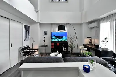 a living room with a couch and a tv at LANG Hotel Ginza 1LDK in Tokyo