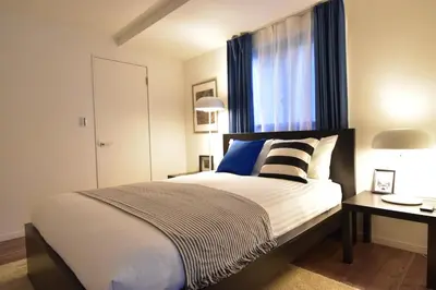 a bedroom with a large bed and a window at LANG Hotel Ginza 1LDK in Tokyo
