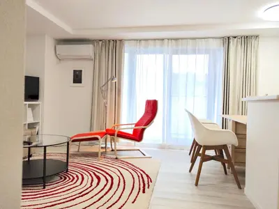 a living room with red chairs and a glass table at LANG Hotel Ginza 1LDK in Tokyo