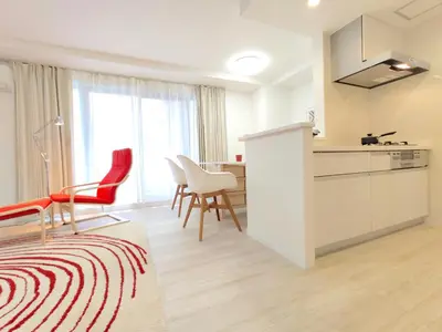 a kitchen with red and white chairs and a table at LANG Hotel Ginza 1LDK in Tokyo