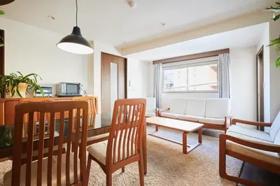 a living room with a couch and a table and chairs at Kyodo Private House in Tokyo
