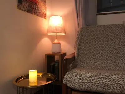 a candle on a table next to a chair and a lamp at Kyodo Private House in Tokyo