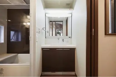 a bathroom with a sink and a mirror and a tub at Kyodo Private House in Tokyo
