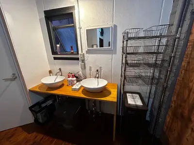 a bathroom with two sinks and a drying rack at Hostel Bedgasm in Tokyo