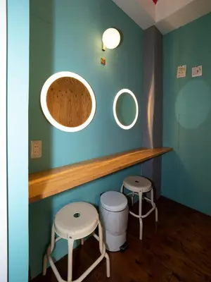 two stools and two mirrors on a blue wall at Hostel Bedgasm in Tokyo