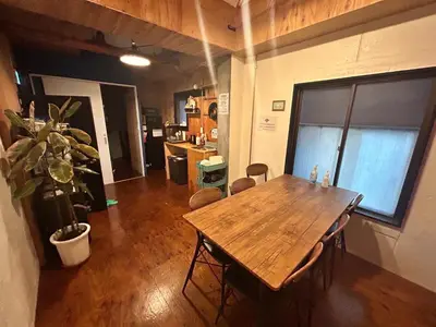 a dining room with a wooden table in a room at Hostel Bedgasm in Tokyo