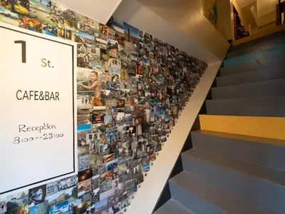 a wall of pictures on a stairwell in a store at Hostel Bedgasm in Tokyo