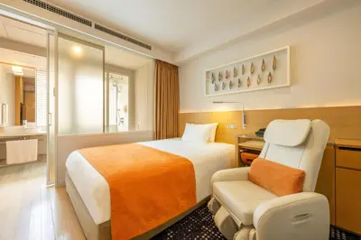 a hotel room with a bed and a chair at remm Hibiya in Tokyo