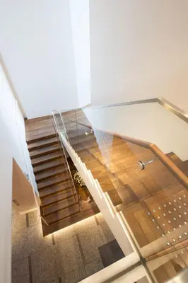 a glass staircase in a building with wooden floors at remm Hibiya in Tokyo