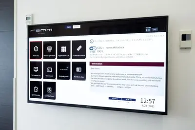 a television screen on a wall with a website at remm Hibiya in Tokyo
