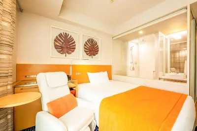 a hotel room with a bed and a chair at remm Hibiya in Tokyo