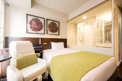 a hotel room with a bed and a chair at remm Hibiya in Tokyo