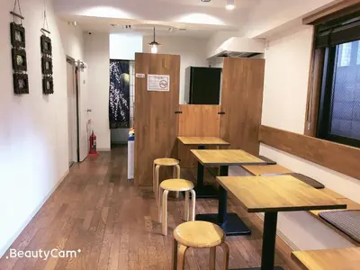 a restaurant with wooden tables and stools at Guest House Siesta in Tokyo