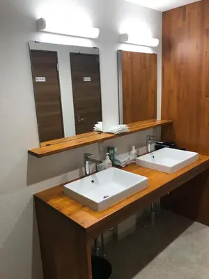 a bathroom with two sinks and two mirrors at Guest House Siesta in Tokyo