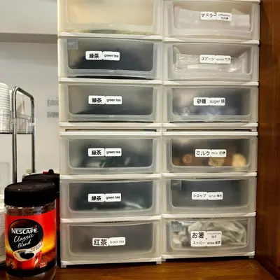 an open refrigerator filled with plastic trays of food at Guest House Siesta in Tokyo