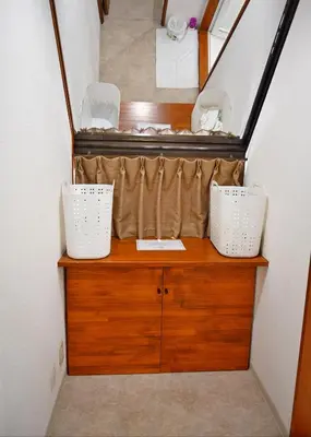a stairway with two baskets on a wooden dresser at Guest House Siesta in Tokyo