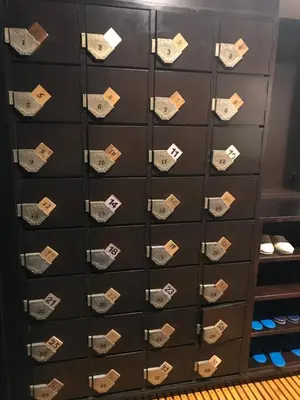 a locker filled with lots of shoes at Guest House Siesta in Tokyo