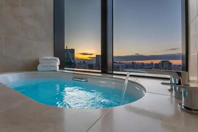 a bath tub with a view of a city at The Okura Tokyo in Tokyo