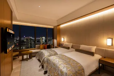 a hotel room with two beds and a television at The Okura Tokyo in Tokyo