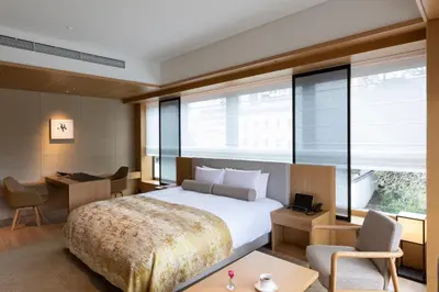a hotel room with a bed and a desk and a window at The Okura Tokyo in Tokyo