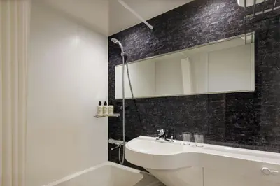 a bathroom with a sink and a mirror and a tub at Four Points Flex by Sheraton Tokyo Shibuya West in Tokyo