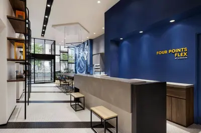 a restaurant lobby with a blue wall and stools at Four Points Flex by Sheraton Tokyo Shibuya West in Tokyo