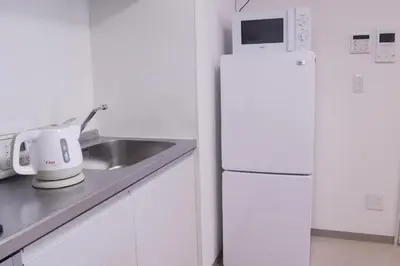 a kitchen with a white refrigerator and a sink at LY INN Ryogoku Annex in Tokyo