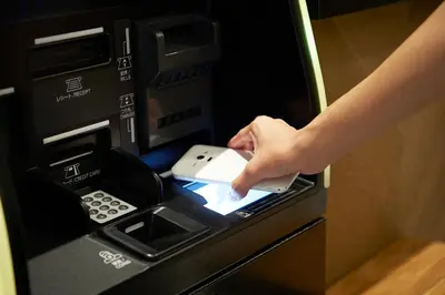 a person putting a credit card into an atm machine at Sotetsu Fresa Inn Nihombashi Kayabacho in Tokyo