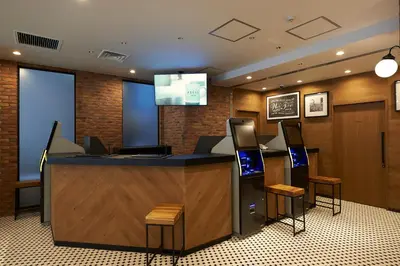 a lobby with a bar with a television and stools at Sotetsu Fresa Inn Nihombashi Kayabacho in Tokyo