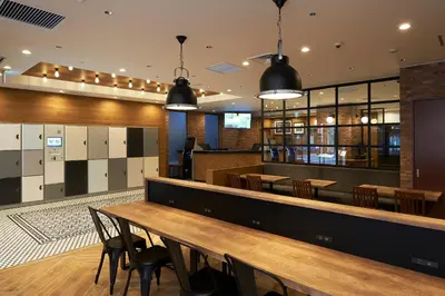 a bar with wooden tables and chairs in a restaurant at Sotetsu Fresa Inn Nihombashi Kayabacho in Tokyo